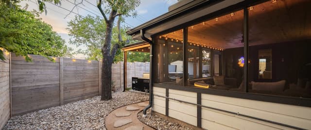 Modern white house with pool, hot tub, and covered patio at sunset
